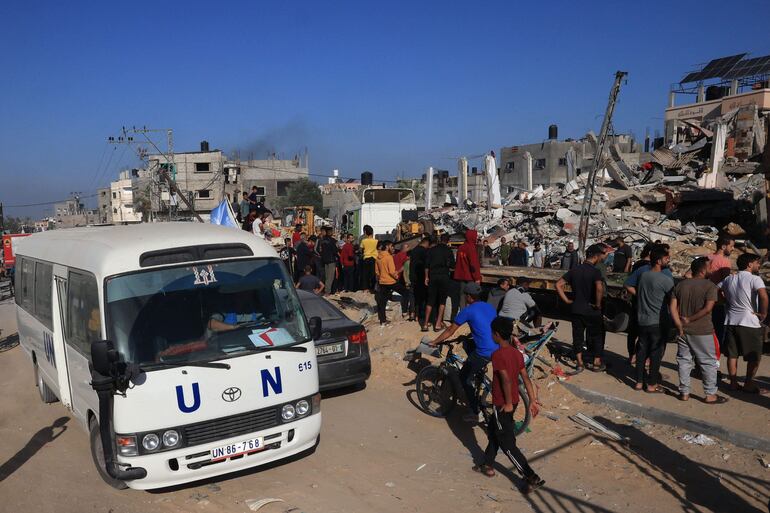 Un autobús de la ONU pasa junto a un edificio destruido tras el bombardeo israelí de Rafah, en el sur de la Franja de Gaza.