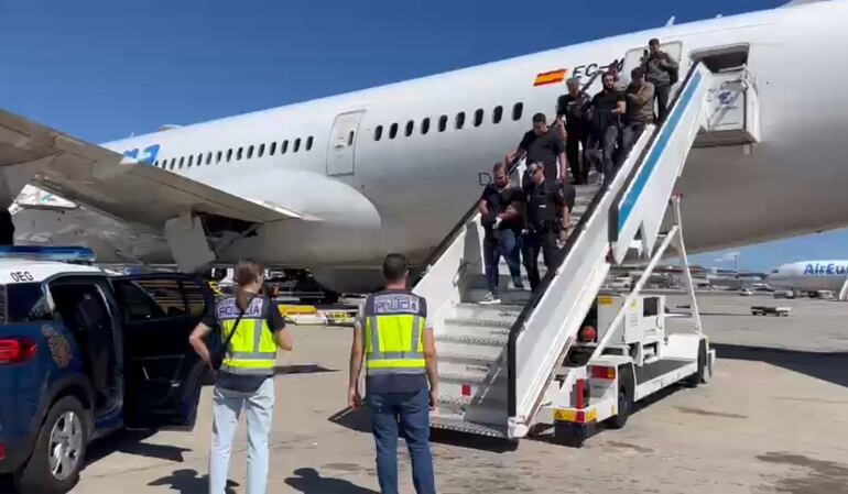 Los  Giuseppe Giorgi, custodiados por policías paraguayos, llegan a España.