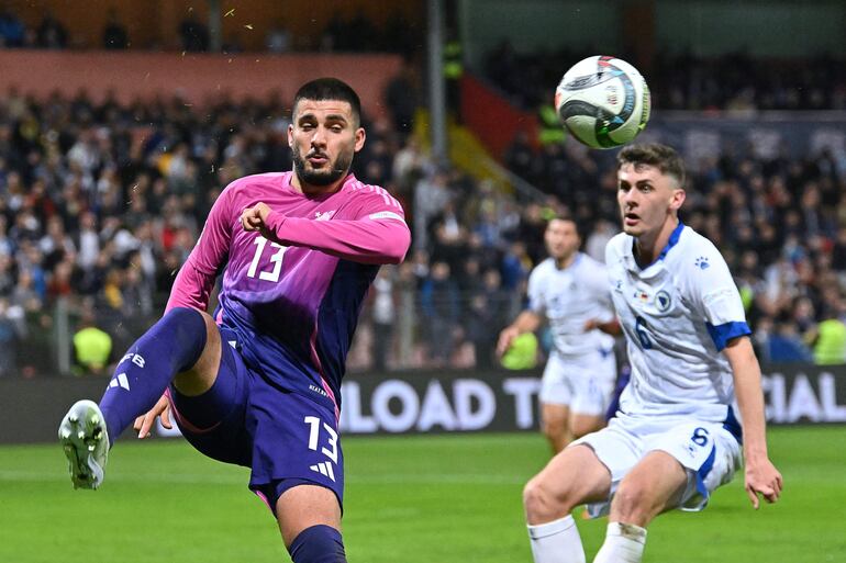 Germany's forward #13 Deniz Undav (L) fights for the ball with Bosnia and Herzegovina's midfielder #06 Benjamin Tahirovic  during the UEFA Nations League, League A - Group 3, football match between Bosnia and Herzegovina and Germany at the Bilino Polje Stadium in Zenica, on October 11, 2024. (Photo by Elvis Barukcic / AFP)