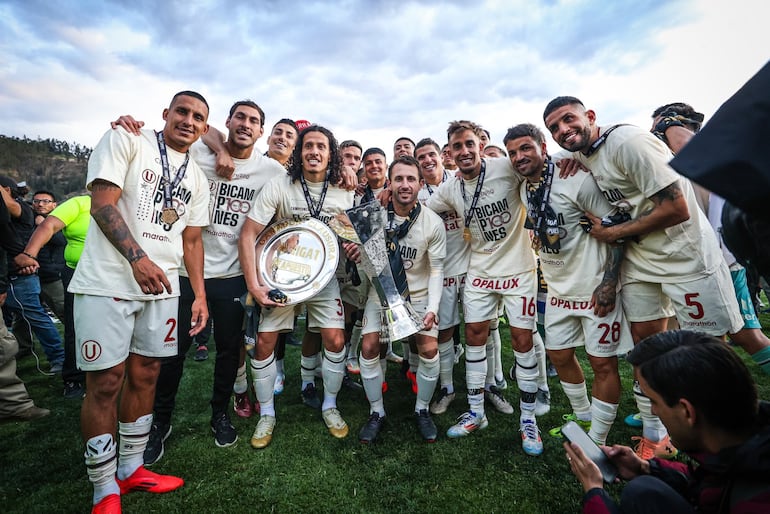 Williams Riveros, con un trofeo en mano, festeja con sus compañeros del Universitario el título de campeón de la liga peruana