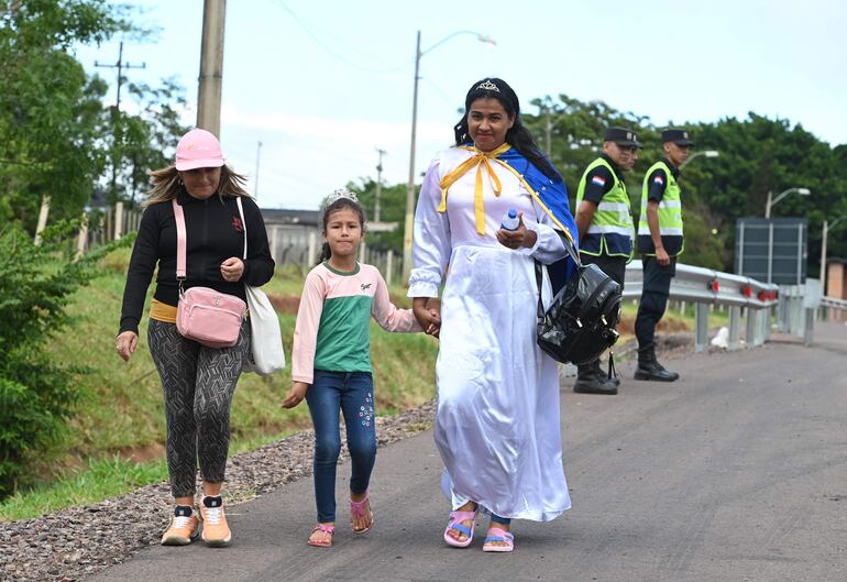 Gladys Rojas, junto a su hija y una amiga, caminan hacia Caacupé para cumplir su promesa.