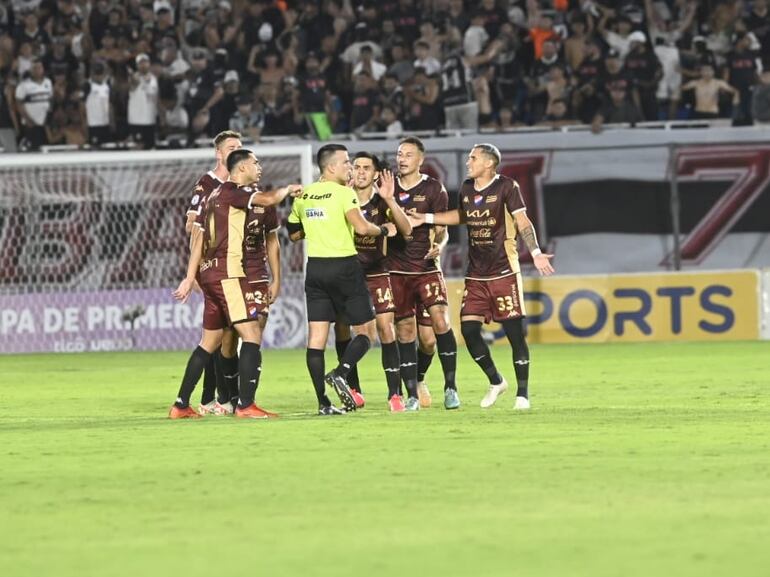 Los jugadores de Nacional protestan al árbitro Derlis Benítez en un partido frente a Olimpia por la tercera jornada del torneo Apertura 2024 del fútbol paraguayo en el estadio Defensores del Chaco, en Asunción.