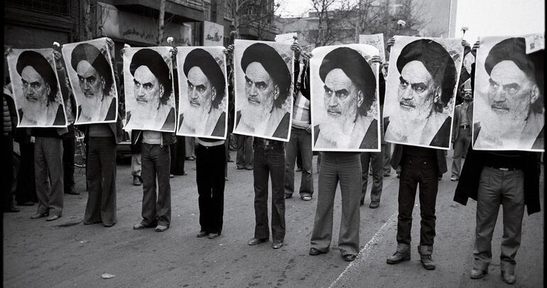 Irán, 1978: fila de hombres con fotos de Jomeini.