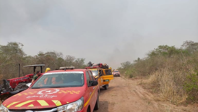 Los voluntarios presurosos buscan salir del lugar ante el avance descontrolado del fuego.