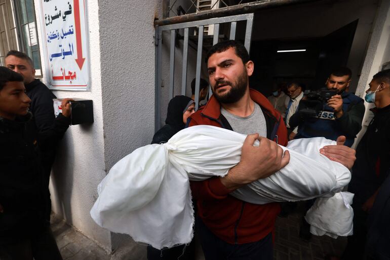 Un hombre lleva en brazos el cuerpo sin vida de una persona fallecida en un bombardeo israelí en Rafah, en la Franja de Gaza, este viernes.