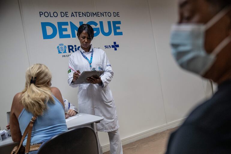 Una trabajadora de la salud revisa a una paciente sospechosa de dengue hoy, en el Centro de Atención de Dengue de la Policlínica Rodolpho Rocco, en el barrio Del Castilho, en Río de Janeiro (Brasil). Brasil, que enfrenta un fuerte aumento de los casos de dengue, tomó este martes nuevas medidas sanitarias en ciudades como Brasilia, Río de Janeiro o São Paulo, que se encuentran entre las regiones más afectadas por esta enfermedad que ha causado la muerte de 36 personas desde el comienzo del año. Desde el 1 de enero, Brasil ha registrado 345.235 casos de dengue con 36 fallecimientos confirmados, a los que se suman 234 muertes en investigación, según los datos oficiales. EFE/ André Coelho