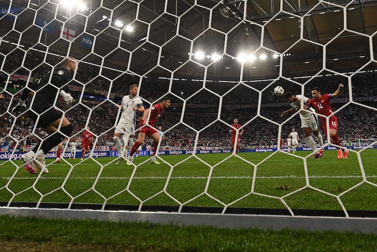 England's midfielder #10 Jude Bellingham heads the ball to score his team's first goal during the UEFA Euro 2024 Group C football match between Serbia and England at the Arena AufSchalke in Gelsenkirchen on June 16, 2024. (Photo by OZAN KOSE / AFP)