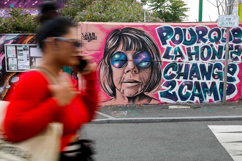 Una mujer pasa junto a un mural creado por Maca_dessine que representa a Gisele Pelicot y una frase que dice "Para que la vergüenza cambie de bando" en Gentilly, al sur de París. Los vídeos grabados por Dominique Pelicot de su mujer, Gisèle, cuando, inconsciente por las drogas que le suministraba, era violada por decenas de hombres a los que el marido invitaba a su casa, van a ser proyectados en el Tribunal de lo Criminal de Aviñón en presencia de público y de la prensa.