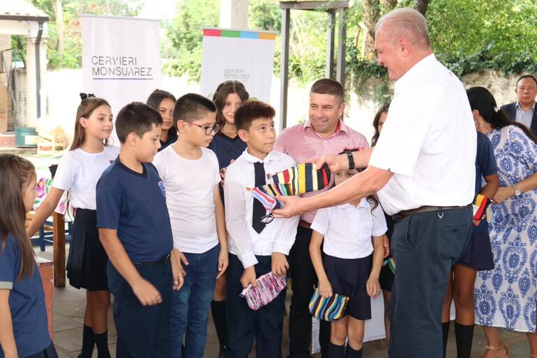 El fiscal general del Estado, Emiliano Rolón, hace entrega de cartucheras textiles a escolares.