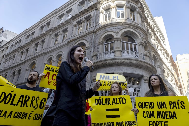 Manifestantes realizan un entierro simbólico del real, moneda brasileña, en protesta contra las acciones del gobierno en el centro de São Paulo (Brasil). Agentes de los mercados financieros han achacado la debilidad del real a las continúas y duras críticas del presidente Luiz Inácio Lula da Silva a la política de altos intereses que defiende el Banco Central, institución autónoma que mantiene los tipos en un 10,5 %, con una inflación controlada en torno al 3,5 % anual. Esta semana será clave para conocer la evolución de los precios en la región, con la publicación del dato de inflación de junio en Estados Unidos, Brasil, México, Argentina y Chile.