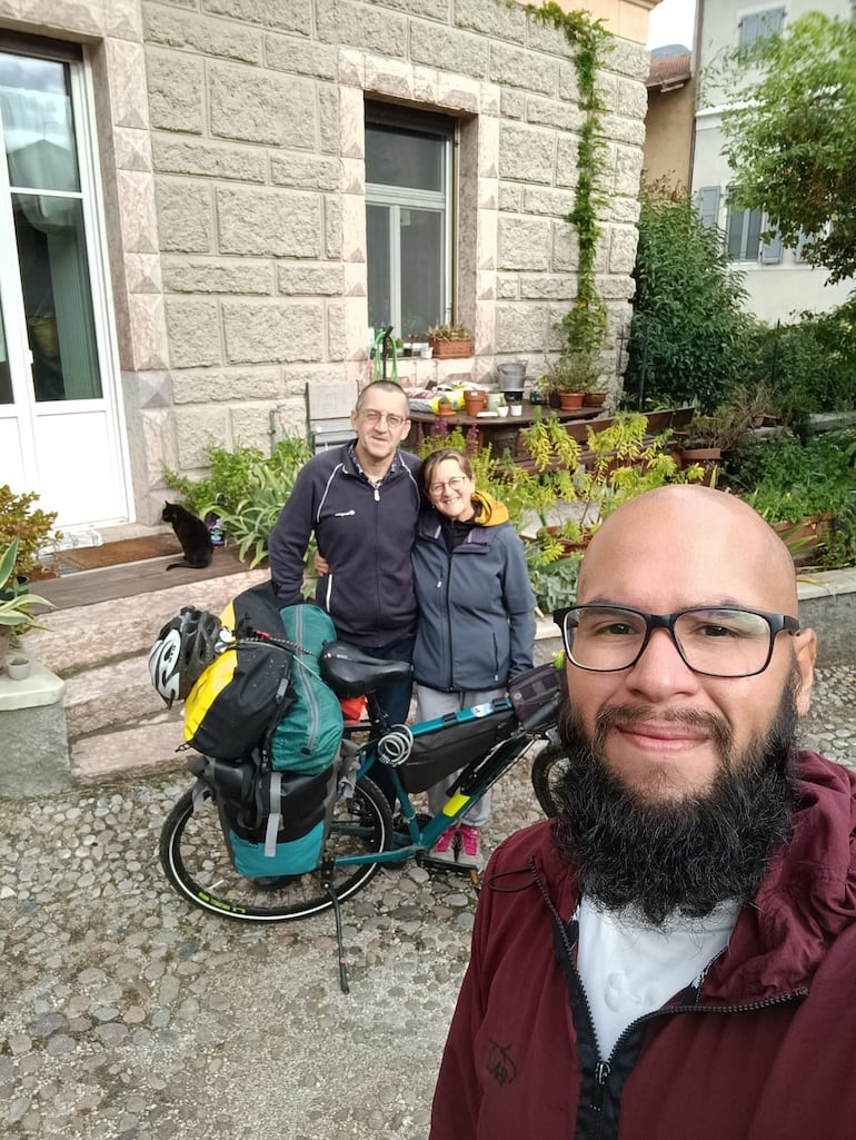 Gabriel López y su bicicleta junto a una pareja en Italia.