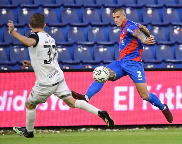 Walter Clar, jugador de Tacuary, en un duelo con Alan Benítez, de Cerro Porteño.