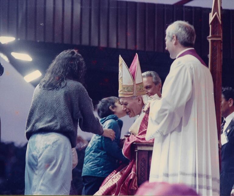 Un niño da un beso al Mensajero del Amor Juan Pablo II.