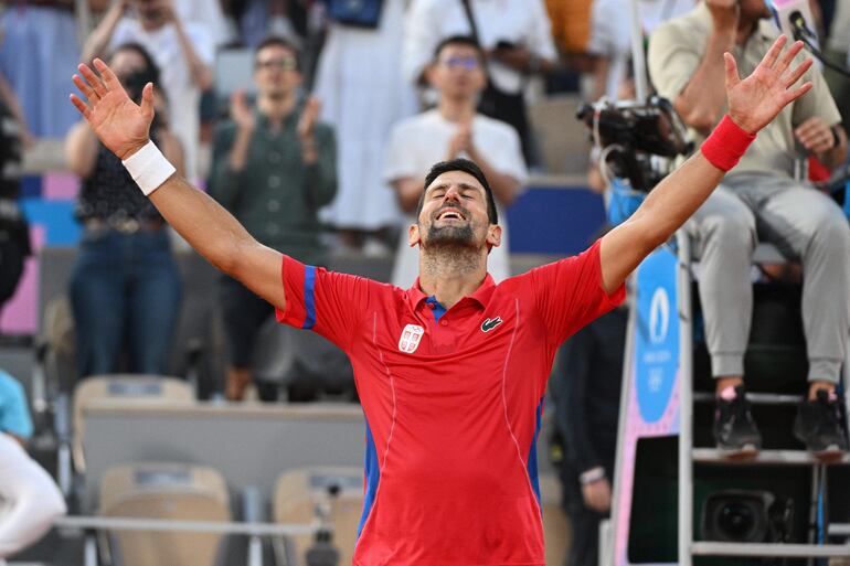 Novak Djokovic de Serbia celebra después de ganar contra Lorenzo Musetti de Italia (invisible) durante su partido semifinal masculino en las competiciones de tenis de los Juegos Olímpicos de París 2024, en Roland Garros en París (Francia), 02 de agosto de 2024. 