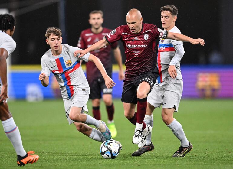 Andrés Iniesta (c) disputa el balón con Gavi durante el partido amistoso de ayer en Tokio.