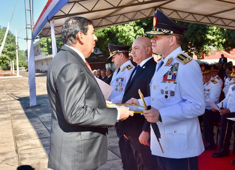 Hermes Garcia Balmaceda recibe un reconocimiento de manos del comandante de la Policía, comisario Carlos Benítez.