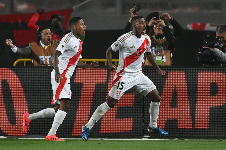 TOPSHOT - Peru's defender #15 Miguel Araujo celebrates with teammate forward #07 Andy Polo after scoring his team's first goal during the 2026 FIFA World Cup South American qualifiers football match between Peru and Uruguay at the National stadium in Lima, on October 10, 2024. (Photo by ERNESTO BENAVIDES / AFP)