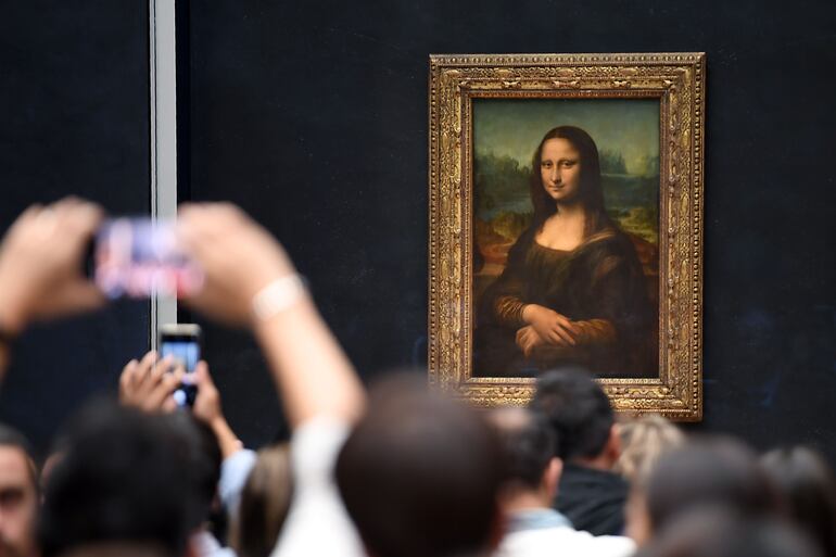 Visitantes del Museo del Louvre, en París, toman una foto de  a La Mona Lisa.