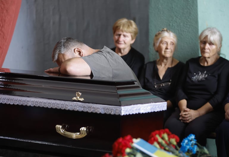 Familiares, amigos y camaradas del difunto militar ucraniano Sergiy Chornyi reaccionan durante su ceremonia funeraria en un cementerio en Kiev, Ucrania, el 05 de agosto de 2024. Rusia urgió este martes a Ucrania a aceptar cuanto antes el plan para acabar con la guerra del jefe del Kremlin, Vladímir Putin, con el argumento de que las tropas ucranianas han sufrido más de 115.000 bajas en menos de dos meses de ofensiva rusa en el norte y este del frente.