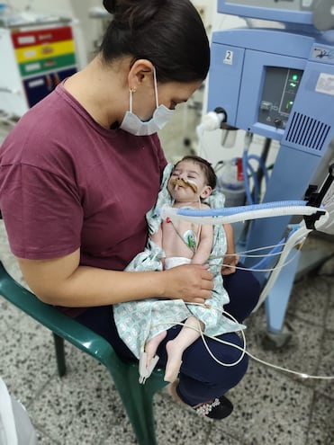 La pequeña Ailana Milagros, en los brazos de su mamá, está internada en terapia intensiva desde setiembre de 2023.