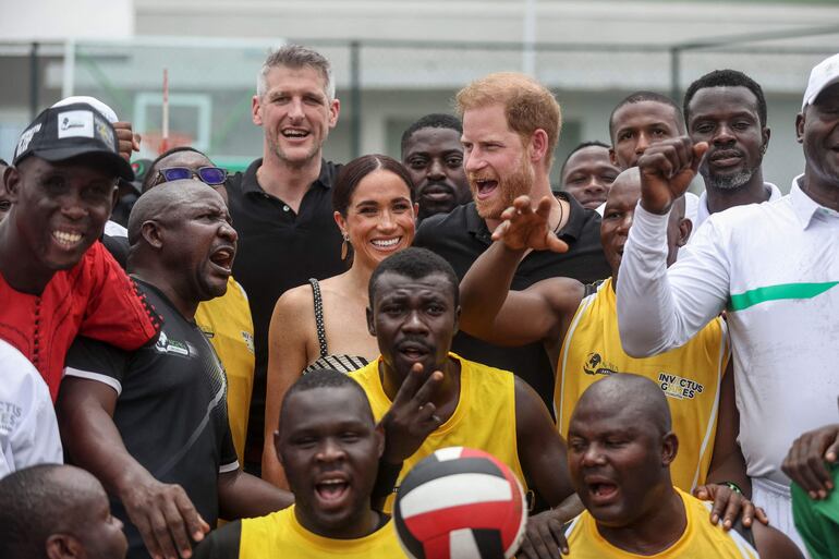 Duques de Sussex posan en una foto con el equipo con el que jugó en Nigeria.