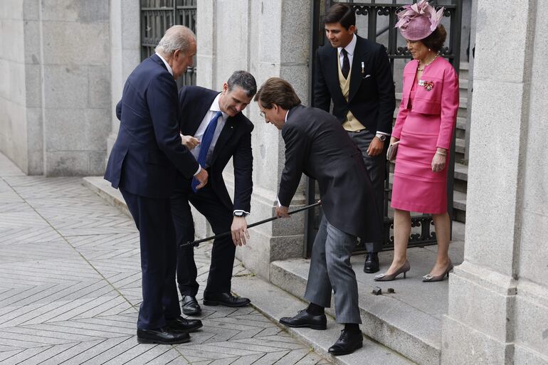 El alcalde de Madrid, José Luis Martínez-Almeida (c), recoge el bastón del rey emérito Juan Carlos I este sábado mientras lo recibe a las puertas de la iglesia de San Francisco de Borja de Madrid antes de contraer matrimonio con Teresa Urquijo. 
