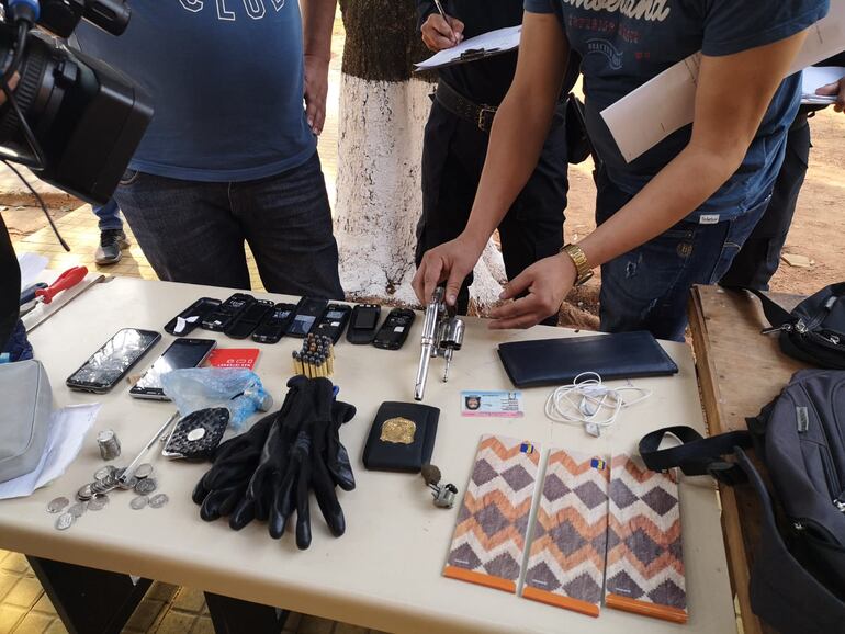 También se encontró un revólver, varias municiones, así como guantes, una placa policial y varias chequeras presumiblemente robadas.