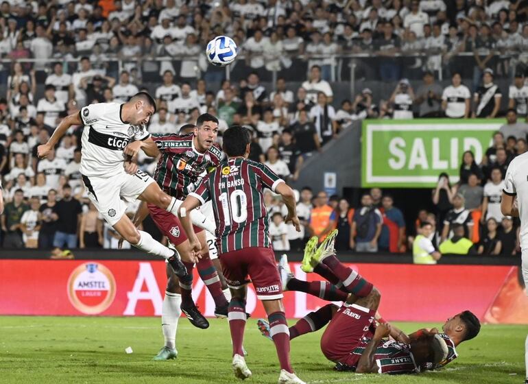 Mateo Gamarra, de Olimpia, ganando de cabeza ante los jugadores de Fluminense.