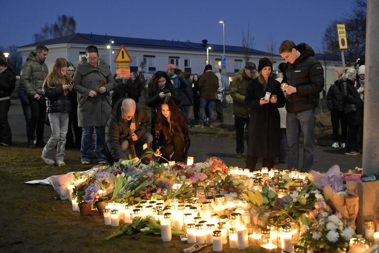 Los dolientes se reúnen para colocar flores y velas en un monumento improvisado después de un tiroteo, en las afueras de la Escuela Risbergska en Orebro, Suecia.