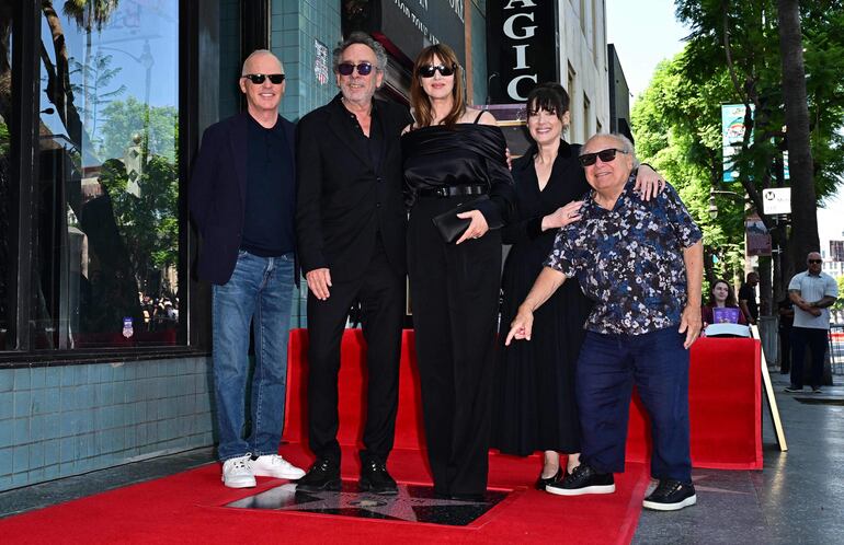 El cineasta estadounidense Tim Burton (2.o a la izquierda) se encuentra en su recién inaugurada estrella del Paseo de la Fama de Hollywood con (de izquierda a derecha) el actor estadounidense Michael Keaton, su esposa, la actriz inglesa Helena Bonham Carter, y los actores estadounidenses Winona Ryder y Danny DeVito durante la ceremonia del Paseo de la Fama en Hollywood, California, 3 de septiembre de 2024. 