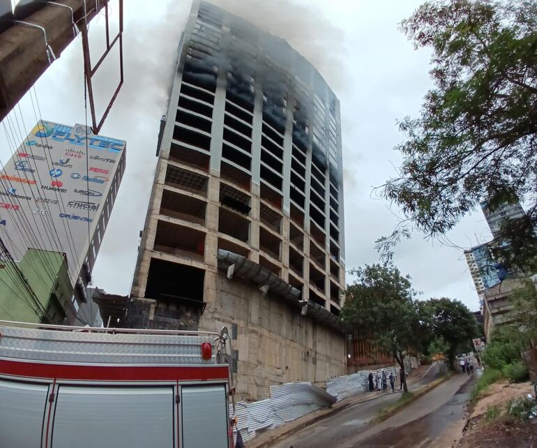 Una gran cantidad de humo sigue saliendo de los pisos superiores del edificio.