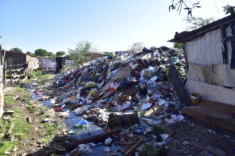 Basura tiene la misma altura que las precarias viviendas de la Chacarita, en Asunción.