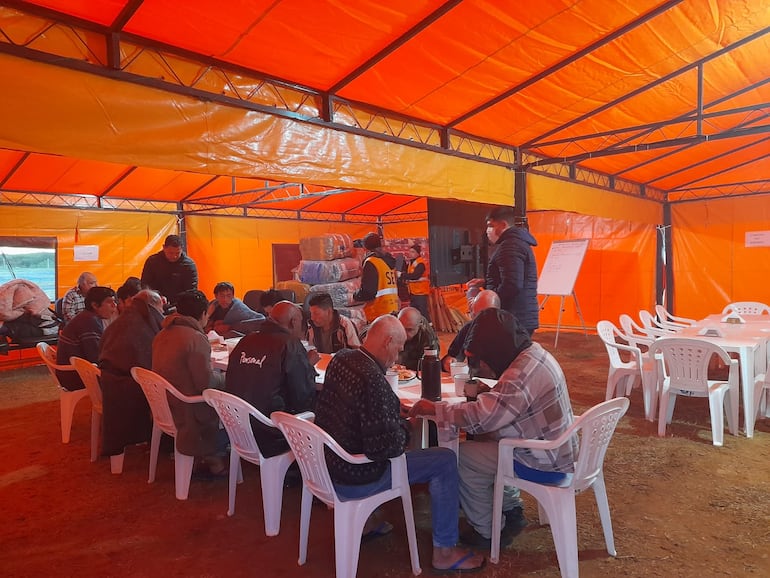 Personas en situación de calle desayunan en el albergue de la SEN en la Costanera, este lunes 12 de junio.