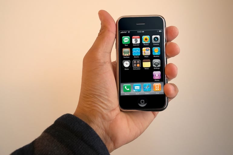 Una mano sostiene un iPhone de primera generación, lanzado el 7 de enero de 2007.