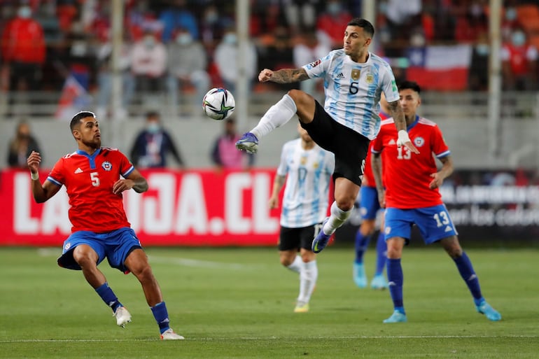 Leandro Paredes (d), jugador de la selección de Argentina, controla el balón durante un partido ante Chile por las Eliminatorias Sudamericanas 2022  en el estadio Zorros del Desierto, en Calama, Chile.