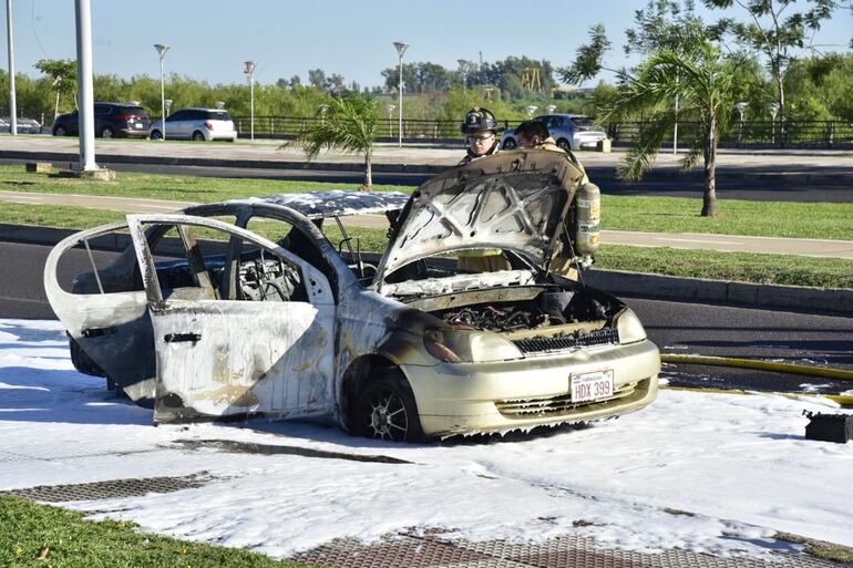 Bomberos hicieron una última verificación del auto incendiado.