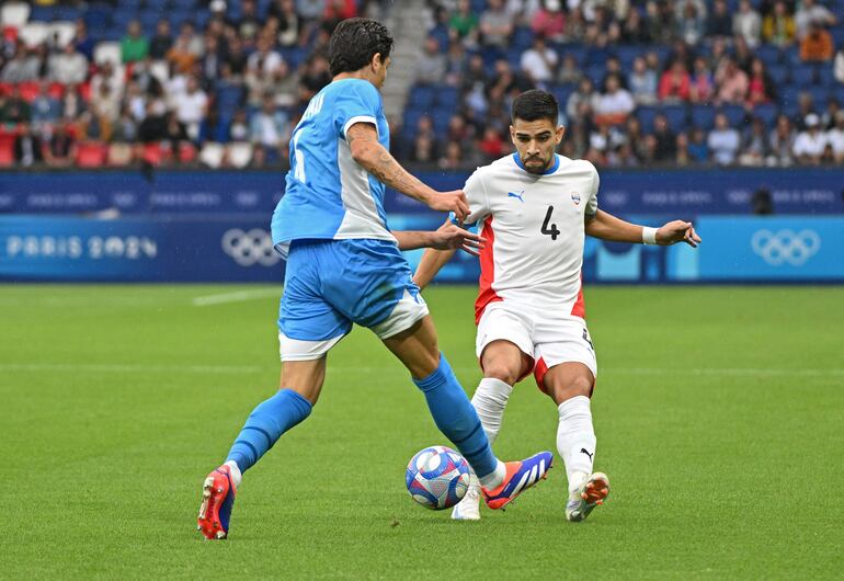 Leonardo Rivas (d), jugador de la selección de Paraguay, pelea por el balón en el partido frente a Israel por la segunda fecha del Grupo D de los Juegos Olímpicos París 2024 en el estadio Parque de los Príncipes, en París, Francia.