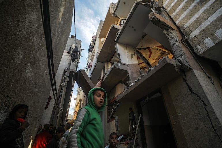 Varias personas junto a un edificio destruido por un bombardeo israelí, el jueves en Deir el Balah, en la zona central de la Franja de Gaza.