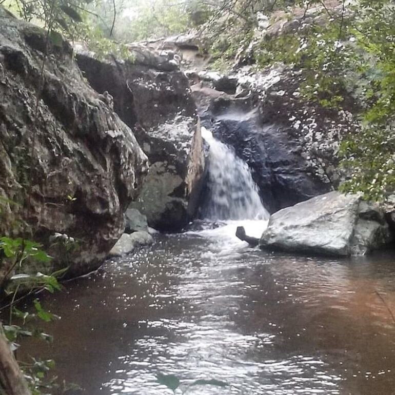 La cascada de agua que corre entre las rocas y que cae al arroyo Paso Carreta.