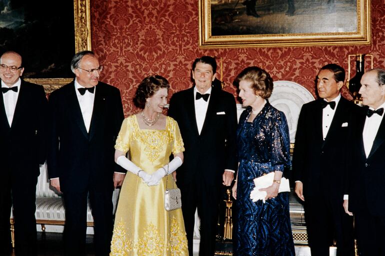 Fotografía tomada en 1984 en la que se observa a la reina Isabel II (c) junto a Margaret Thatcher, la primera mujer en ocupar el cargo de Primer Ministro del Reino Unido.  (AFP, archivo)