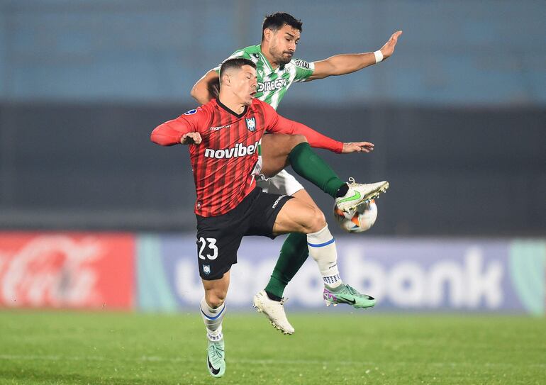 TOPSHOT - Huachipato's Paraguayan forward Cris Martinez (Front) and Racing's defender Guillermo Cotugno fight for the ball during the Copa Sudamericana knockout round playoff second leg football match between Uruguay's Racing and Chile's Huachipato at the Centenario stadium in Montevideo on July 23, 2024. (Photo by DANTE FERNANDEZ / AFP)