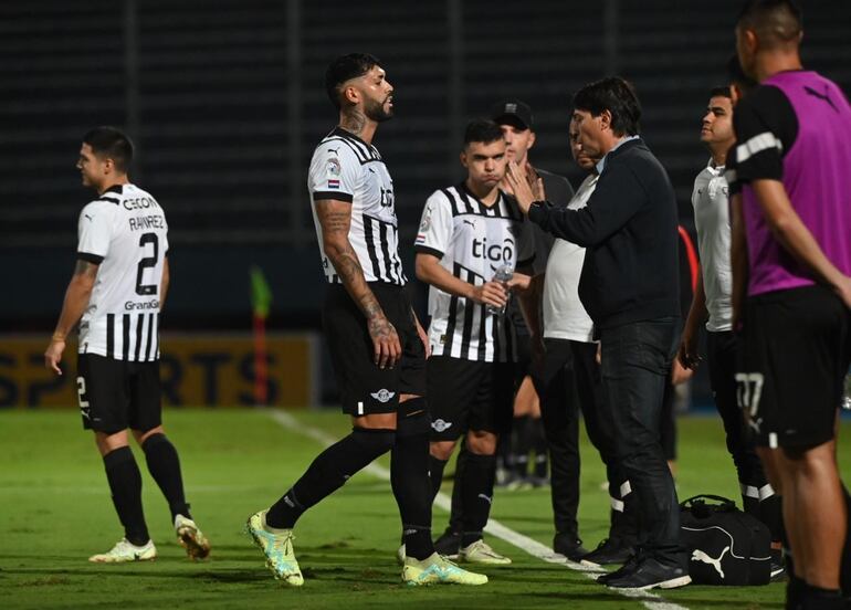 Alexander Barboza (i), defensor de Libertad, conversa con el entrenador de Daniel Garnero después de la expulsión del jugador.