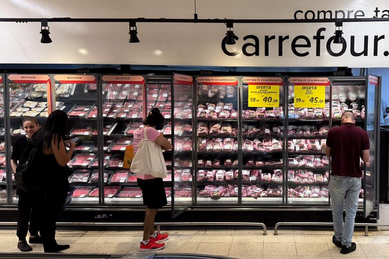 BRA100. SAO PAULO (BRASIL), 25/11/2024.- Personas observan la estantería de carnes en un supermercado Carrefour este lunes en São Paulo (Brasil). La brasileña JBS, la mayor empresa cárnica del planeta, suspendió el suministro a los supermercados de Carrefour en Brasil en protesta por la decisión del grupo de que sus tiendas en Francia dejen de comprar carne del Mercosur, informaron este lunes a EFE fuentes conocedoras de la medida. EFE/ Isaac Fontana
