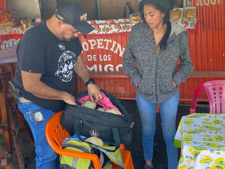 Uno de los agentes especiales realiza la revisión de los bolsos bajo la atenta mirada de la ahora detenida.