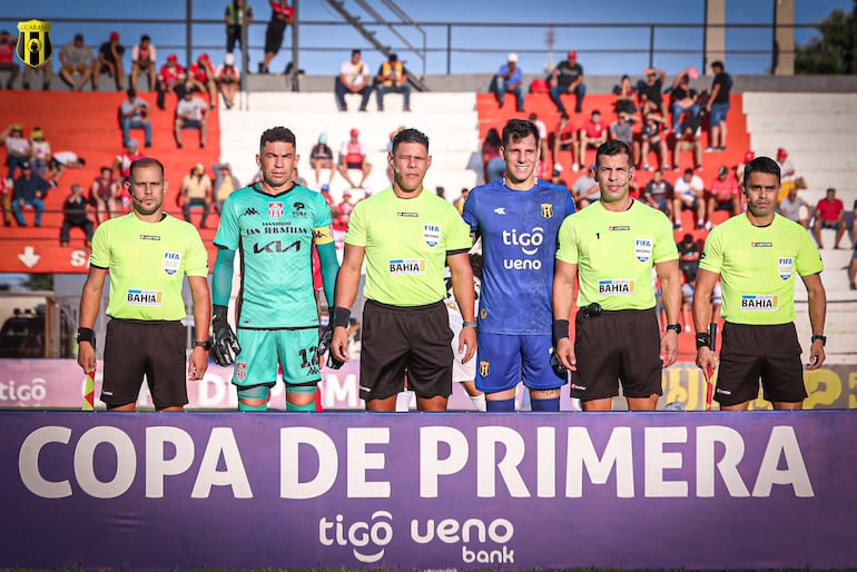 Gustavo Arévalos, arquero de General Caballero, y Gaspar Servio, golero de Guaraní, en la previa del partido junto al árbitro Blas Romero y sus asistentes.