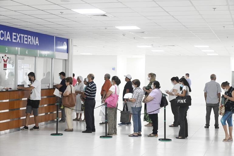 Asegurados forman fila para retirar medicamentos de la farmacia. 