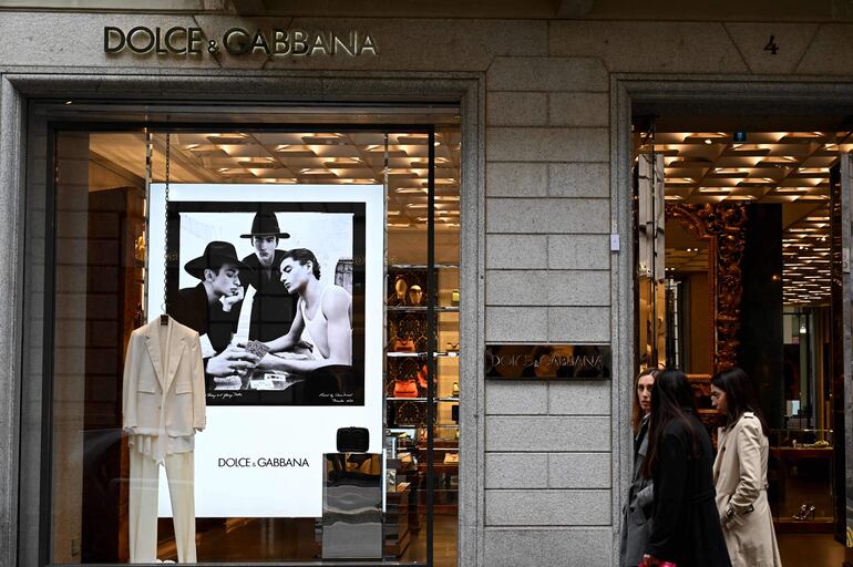 La gente pasa por la boutique Dolce & Gabbana en Via Monte Napoleone, una famosa calle comercial de lujo en Milán.