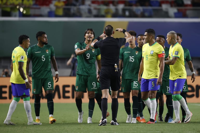 El árbitro paraguayo Juan Benítez (c) habla con los jugadores de Brasil y Bolivia en un partido de las Eliminatorias Sudamericanas para la Copa Mundial de Fútbol 2026 entre Brasil y Bolivia en el estadio estatal Jornalista Edgar Augusto Proençaen Belém (Brasil).