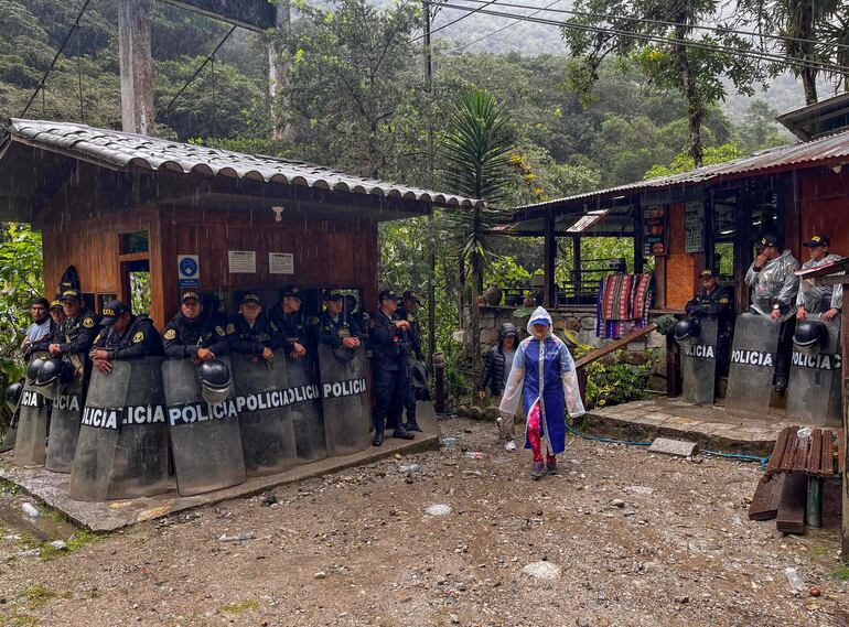 La policía antidisturbios protege la entrada al sendero que conduce a las ruinas del Pueblo Machu Picchu, Perú, el 28 de enero de 2024. Los turistas continúan llegando a la ciudad que sirve a Machu Picchu en Perú a pesar de que los lugareños bloquean el tren turístico que conduce a la mundialmente famosa ciudadela Inca.