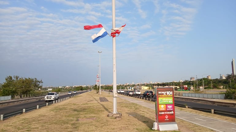 Bandera de Paraguay y de Asunción flamean rotas en la Costanera de Asunción.